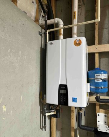 Tankless water heater mounted on wall with digital display and connected plumbing, highlighting Azerplumb's installation and repair services for efficient hot water solutions.