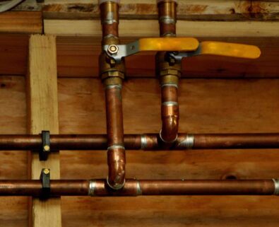 Copper plumbing pipes with valve, showcasing water line installation for plumbing services in Forsyth County, GA.